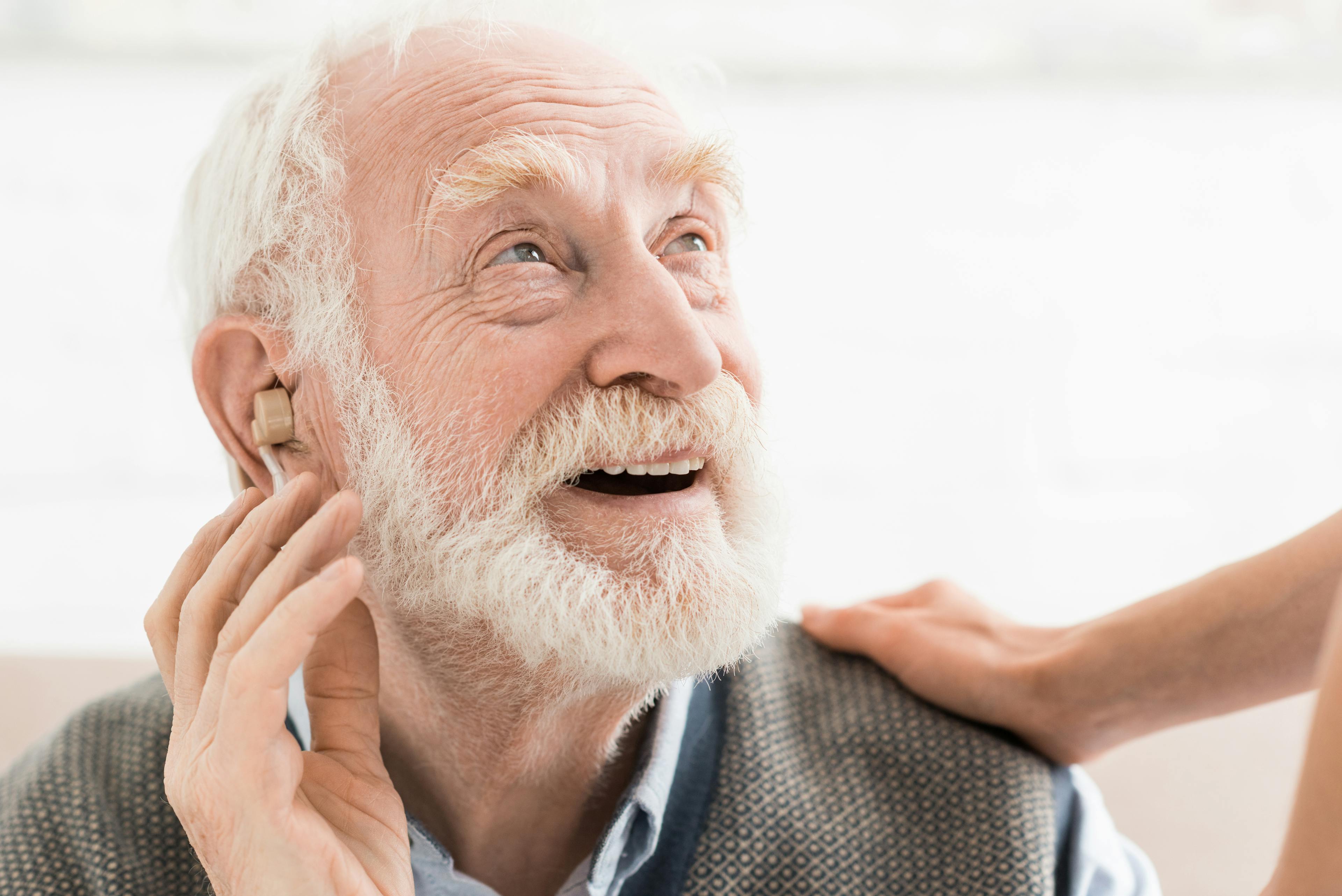 Smiling man with hearing aid.