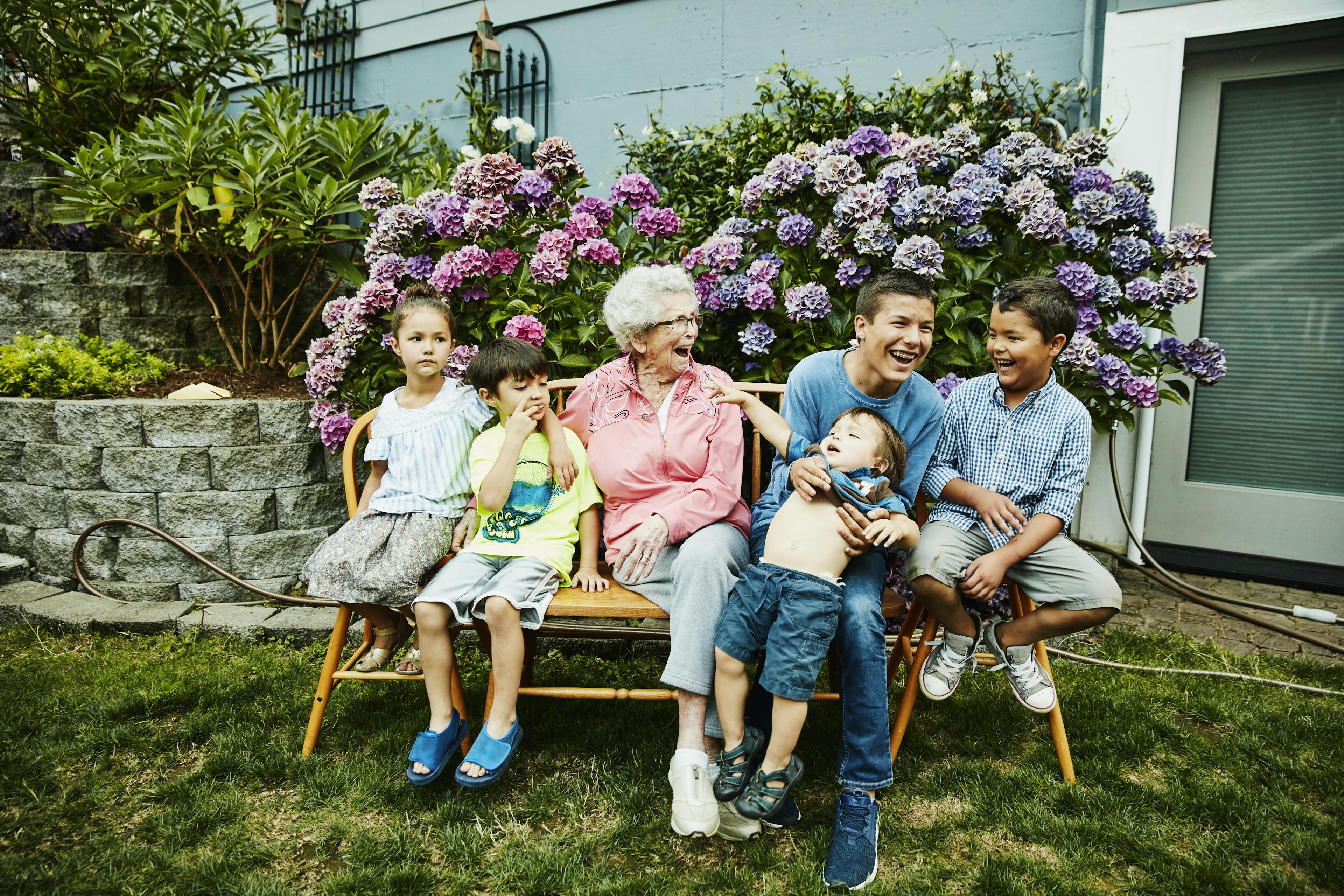 Grandmother in garden with grandchildren.