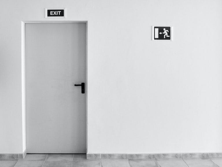 Picture of a door in a white hallway.
